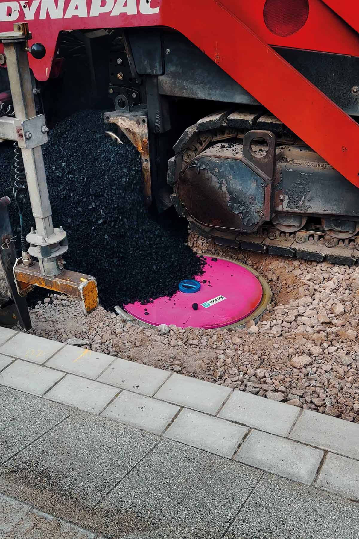 Der TIBATEK®-Asphaltdeckel verschließt einen Schacht während Verdichtungsarbeiten